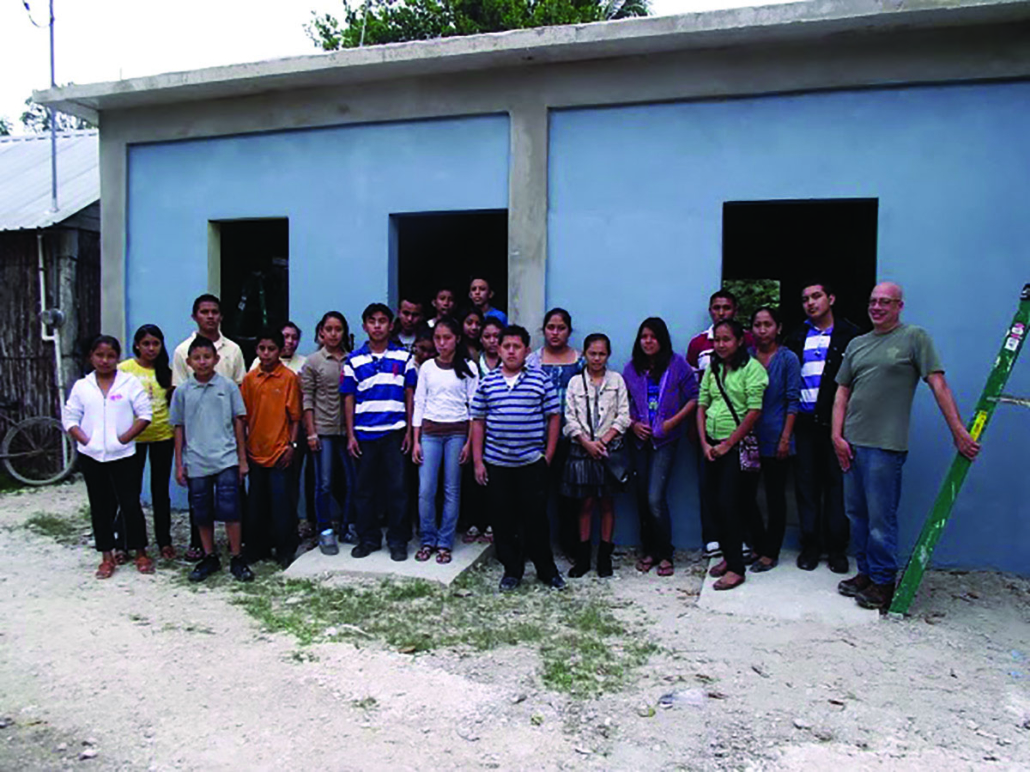 Large group of students outside of a blue building